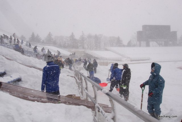 写真：吹雪のなか雪かきをするサポーターたち