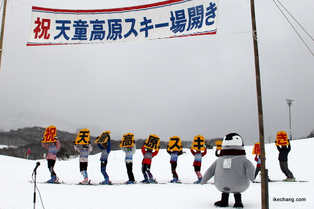 写真：デモ滑走をした天童市スキースポーツ少年団の皆さんと「天ギンちゃん」（天童高原スキー場開き）