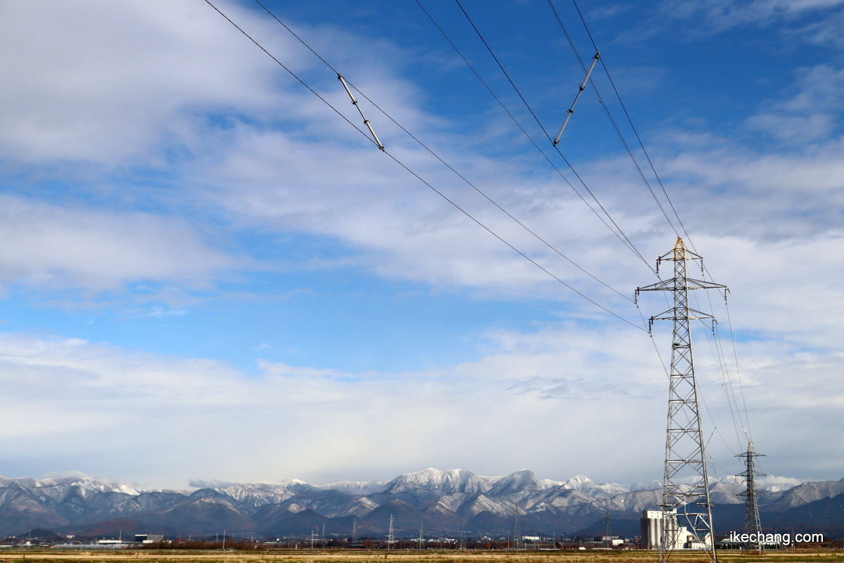 写真：青い空と白い山々と鉄塔