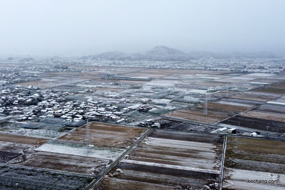 写真：雪で白くなった塚野目集落と奥に見える舞鶴山（ドローンで空撮）