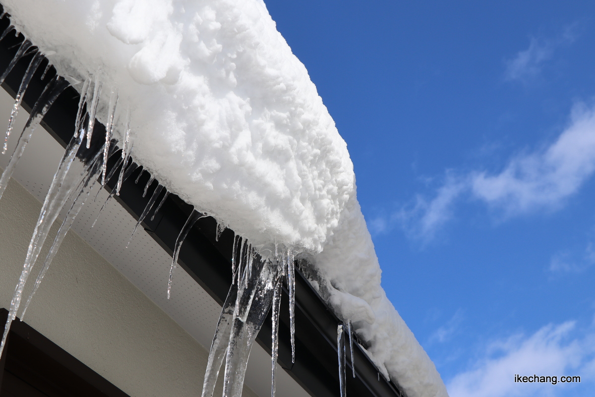 写真：青空と屋根の雪とツララ